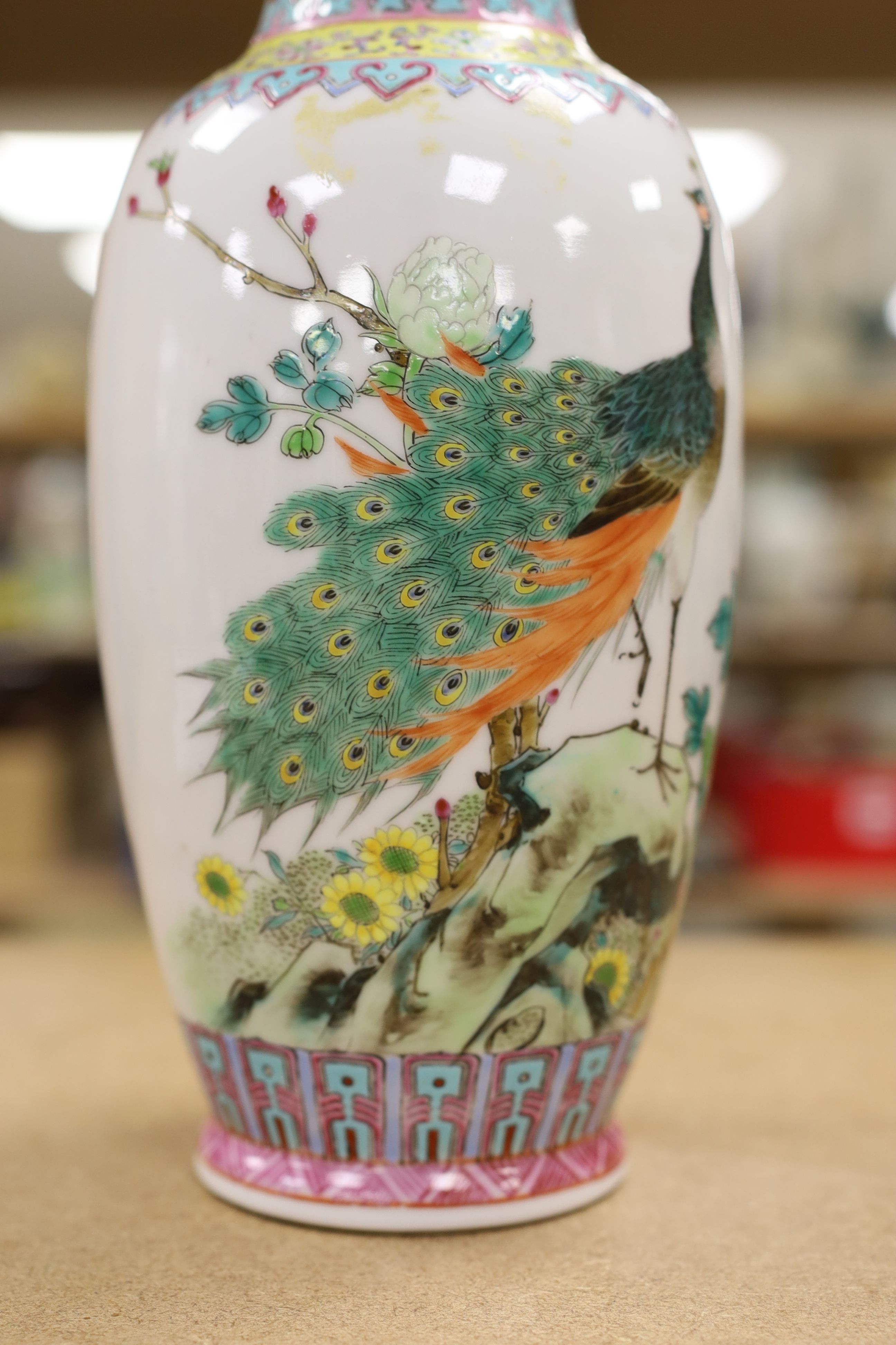 A pair of Chinese famille rose vases decorated with peacocks, 31cm